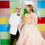 a couple dances around in front of a colorful glass wall at Madonna Inn