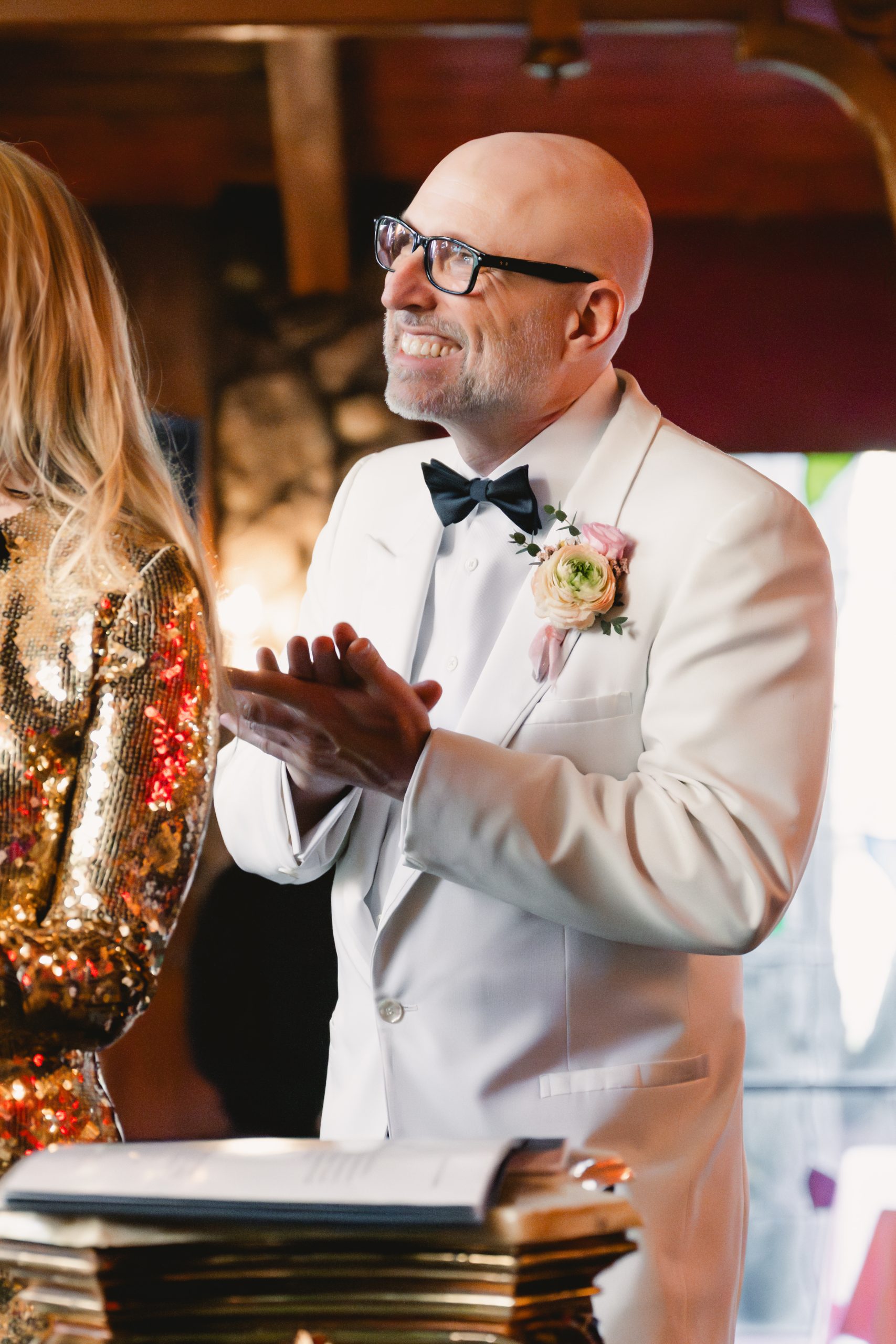 groom claps for the bride as she walks down the stairs