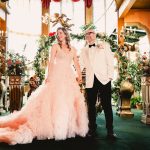 the laughing couple looks out at their wedding guests from the stage