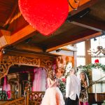 a blonde bridein a pink wedding gown reads her vows on stage at Madonna Inn