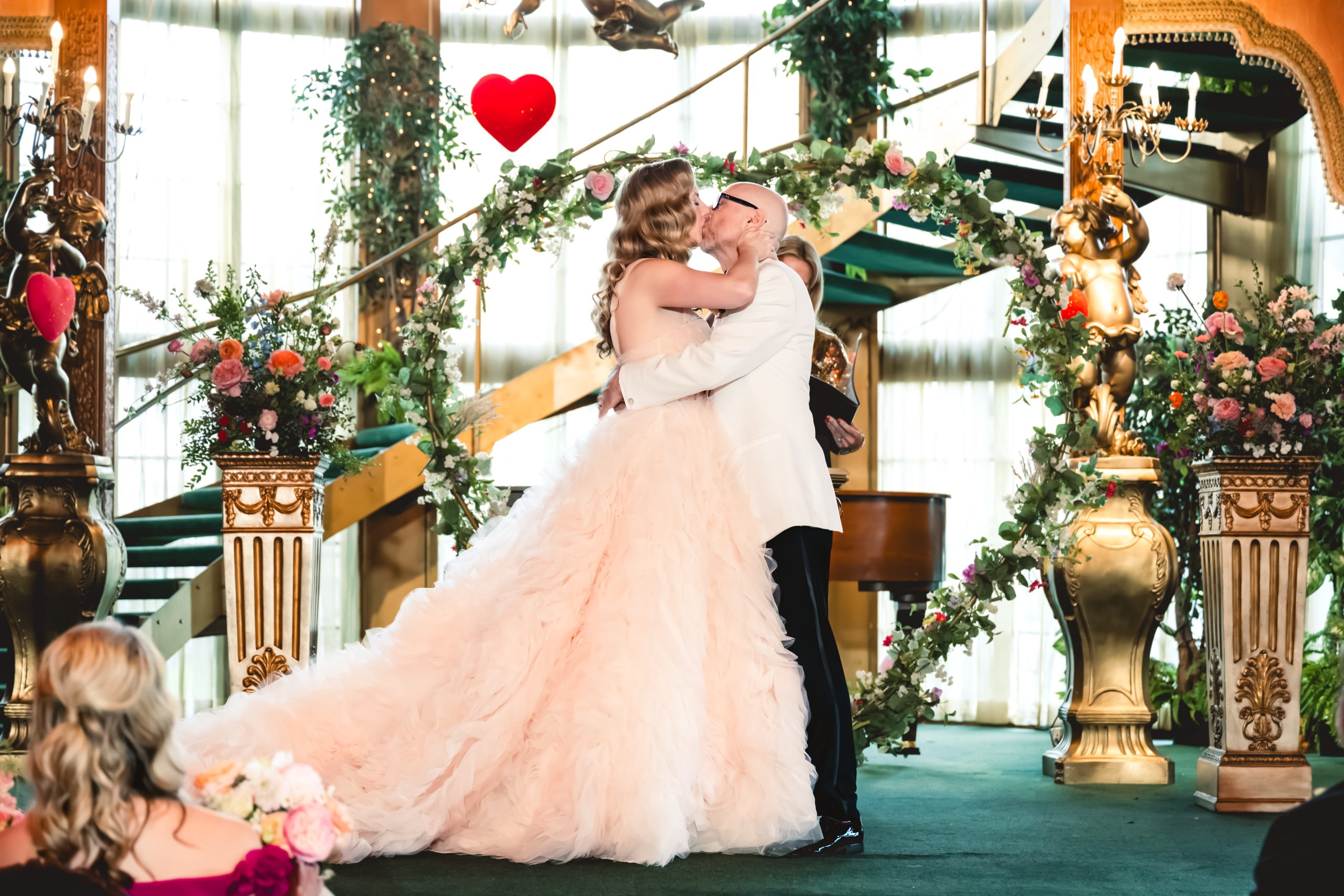 the bride and groom share their first kiss as a married couple surrounded by the quirky Madonna Inn decor