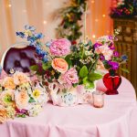 pink, red, blue florals, glass vases and vintage elements decorate the sweetheart table at madonna inn