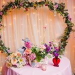 pink, red, blue florals, glass vases and vintage elements decorate the sweetheart table at madonna inn
