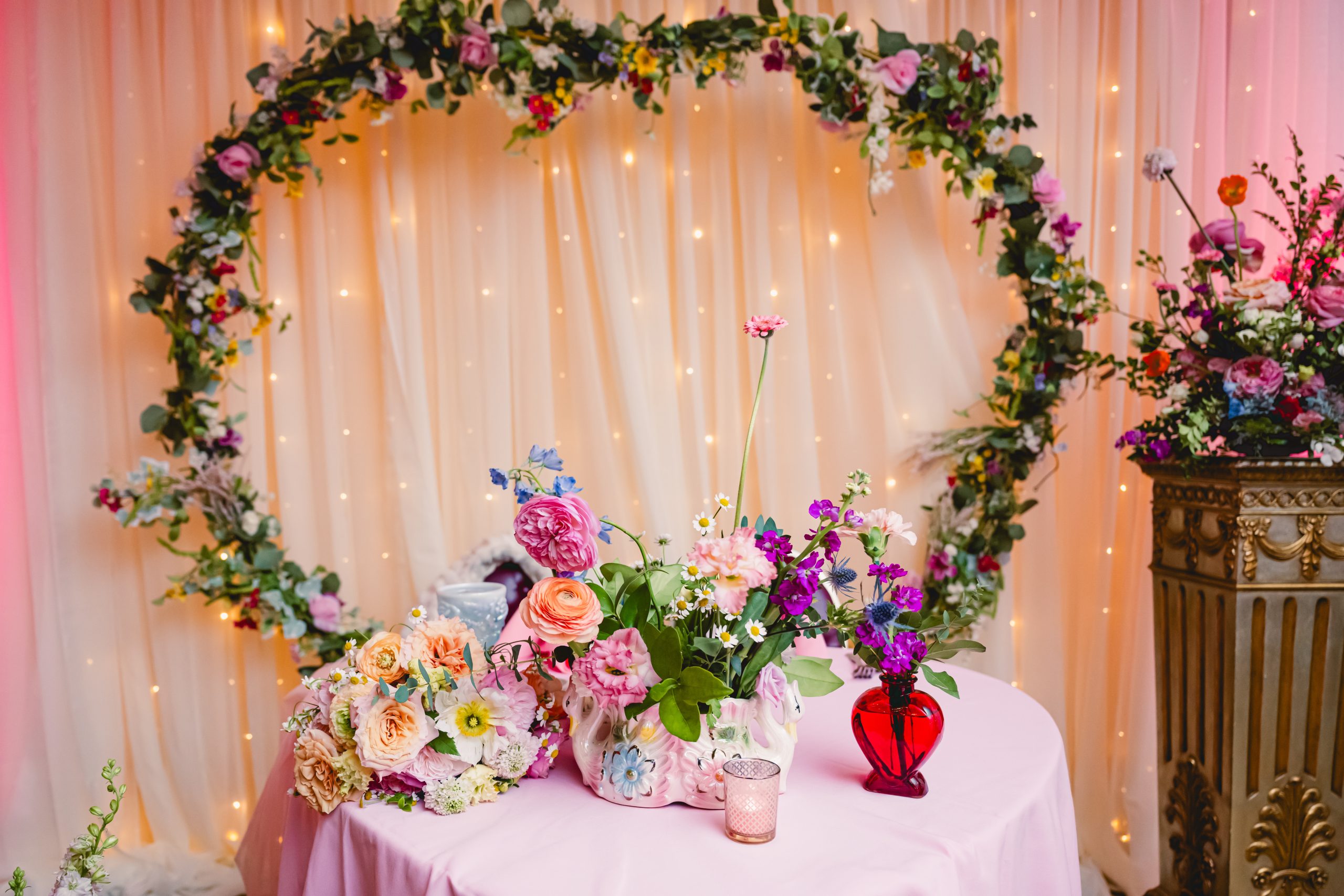 pink, red, blue florals, glass vases and vintage elements decorate the sweetheart table at madonna inn