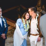 wedding guests enjoy the ceremony and hold onto each other happily