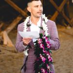 a guest wearing a purple suit and a lei reads a passage at this malibu beach elopement ceremony