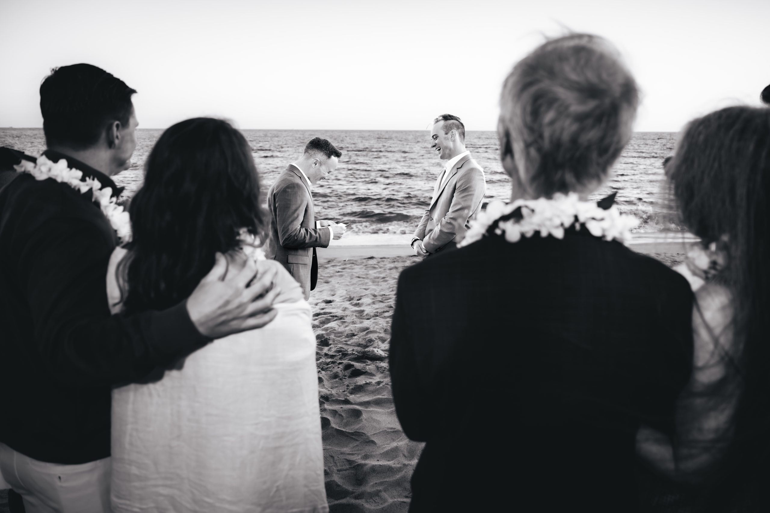 a touching moment as the couple reads their vows with their guests holding onto each other in the foreground