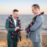 two grooms exchange rings as the sun sets over the ocean in malibu