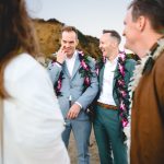 the husbands share a joke as they laugh with their wedding guests